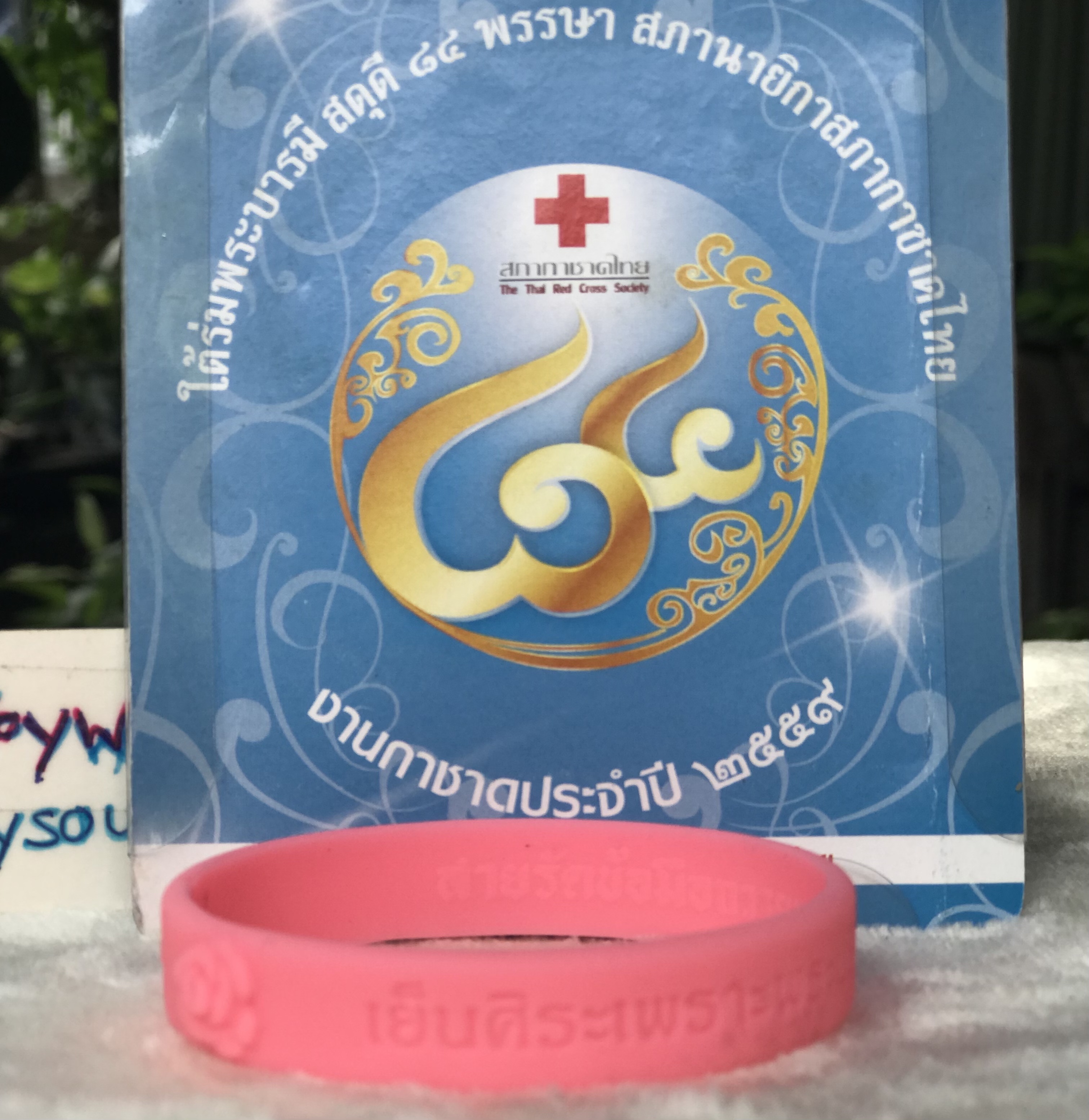 สายรัดข้อมือดอกกุหลาบชมพู วาระเฉลิมพระชนมพรรษา 84 ปี พระราชินีในรัชกาลที่ 9 หมายเลขกำกับ 227039 จัดทำโดยสภากาชาดไทย