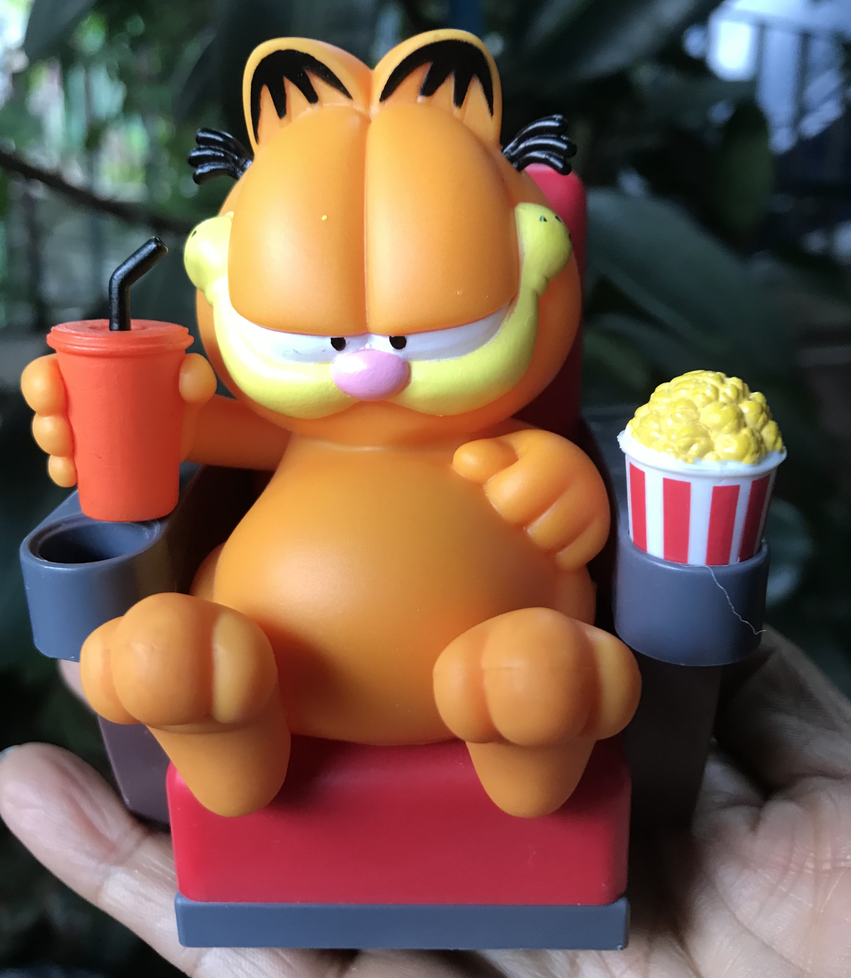 ￼แมวส้มการ์ฟิลด์จอมแสบ Topper Garfiled : Garfield sitting in a movie theater chair with a drink and popcorn