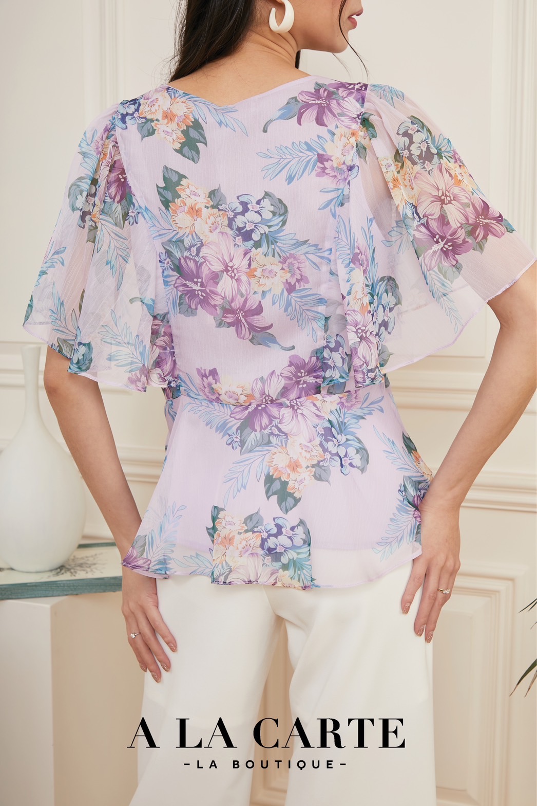 69162 A la carte เสื้อชีฟองเนื้อเยื่อไม้ พิมพ์ลายดอกสีพาสเทล คอวีแต่งผูกโบไขว้ช่วงกลางลำตัว ระบายชายเสื้อ ทรงจะเข้ารูปเล็กน้อย แขนระบายหวานๆช่วยพรางต้นแขน สีม่วง S-M ดำ S,L