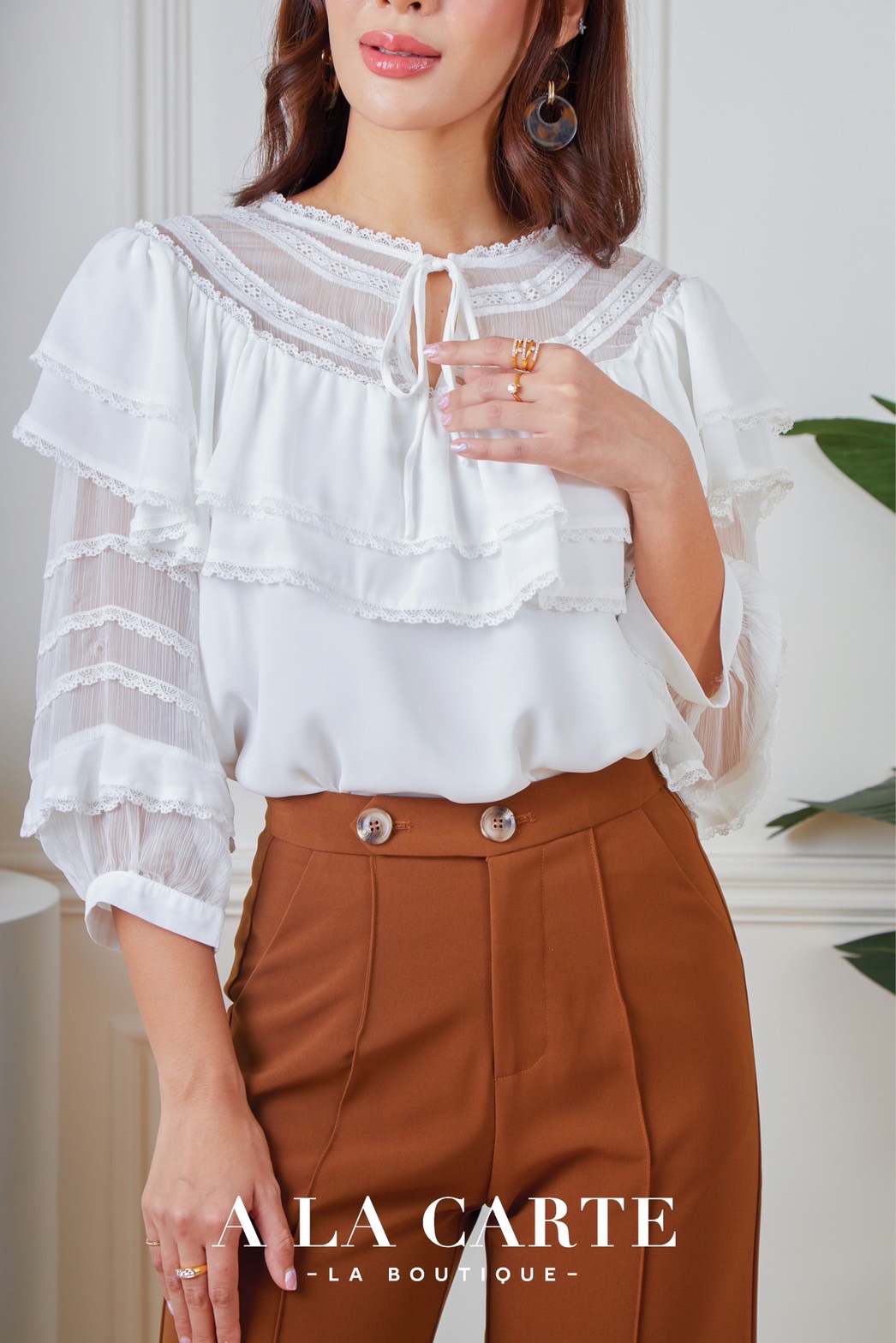 68591 A LA CARTE เสื้อผ้าจอเจียร์สีแขน 3 ส่วน เนื้อเนียนมีน้ำหนักใส่สบาย ช่วงคอตัดต่อด้วยผ้าเนื้อเยื่อไม้ เย็บกดเส้นทริมเรียง ต่อระบายผ้า 2 ชั้น ด้านหน้ามีผ่าผูกโบว์ แขนตัดต่อผ้าทรงพอง สีชมพู น้ำตาล S,L,XL ขาว M-2XL
