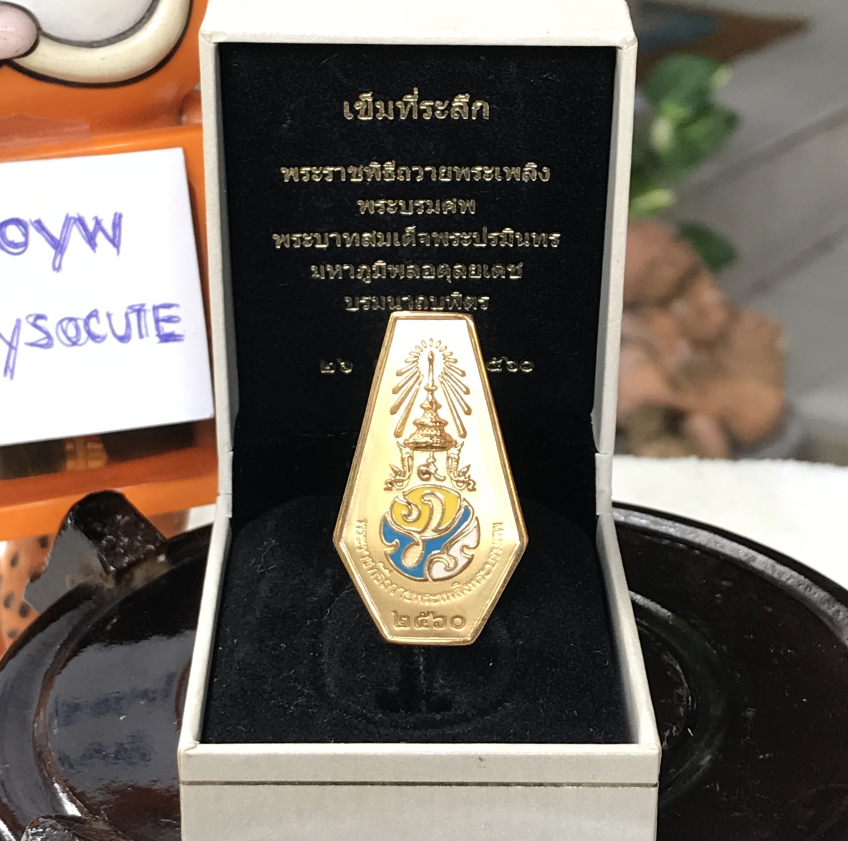 เข็มกลัด เข็มที่ระลึกพระราชพิธีถวายพระเพลิงพระบรมศพพระบาทสมเด็จพระปรมินทรมหาภูมิพลอดุลยเดช บรมนาถบพิตร รัชกาลที่ 9 สำนักงานปลัดสำนักนายกรัฐมนตรี (สปน.) / 26 ตุลาคม 2560