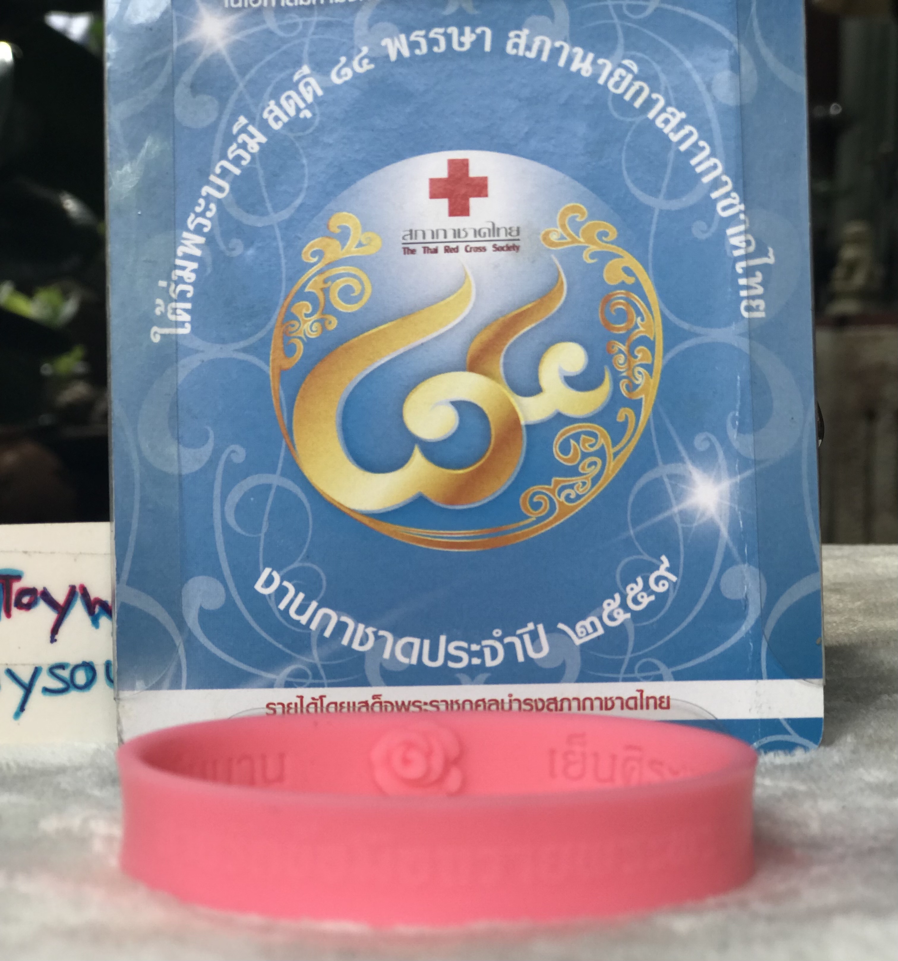 สายรัดข้อมือดอกกุหลาบชมพู วาระเฉลิมพระชนมพรรษา 84 ปี พระราชินีในรัชกาลที่ 9 หมายเลขกำกับ 227039 จัดทำโดยสภากาชาดไทย