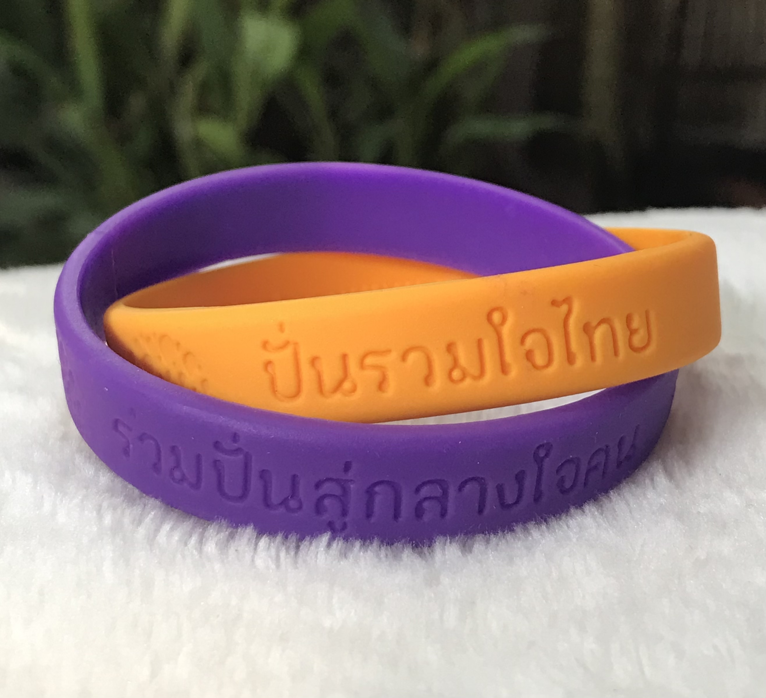 Wristband สายรัดข้อมือแบบไขว์สองเส้น"ปั่นรวมใจไทย" ปี 2558 เพื่อเทิดพระเกียรติรัชกาลที่ 9/สมเด็จพระเทพ โดยมูลนิธิพระดาบส
